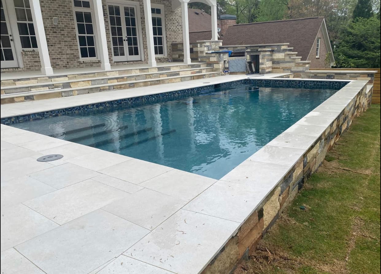 Stone steps and walkways connecting pool and patio levels.