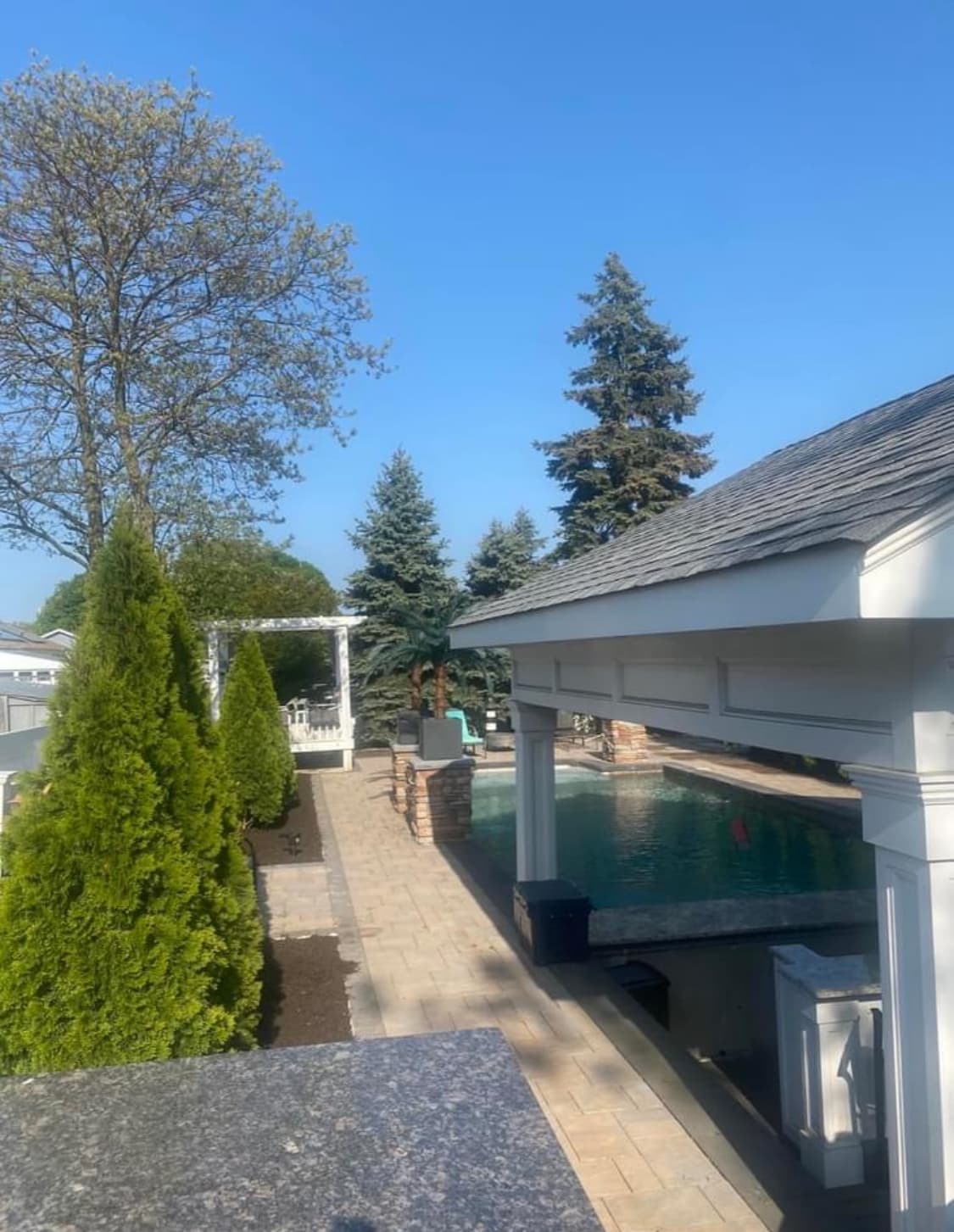 Fire feature and seating area beside a lit pool at dusk.