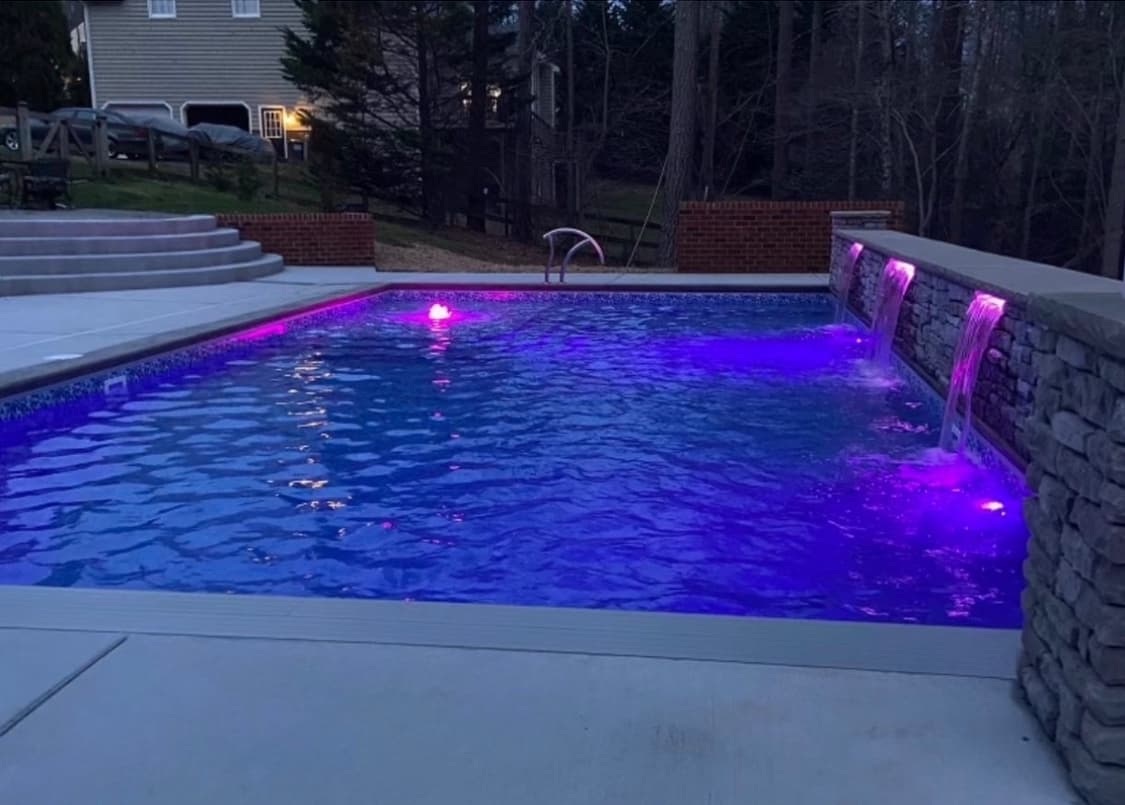 Pool with dramatic LED lighting at twilight.