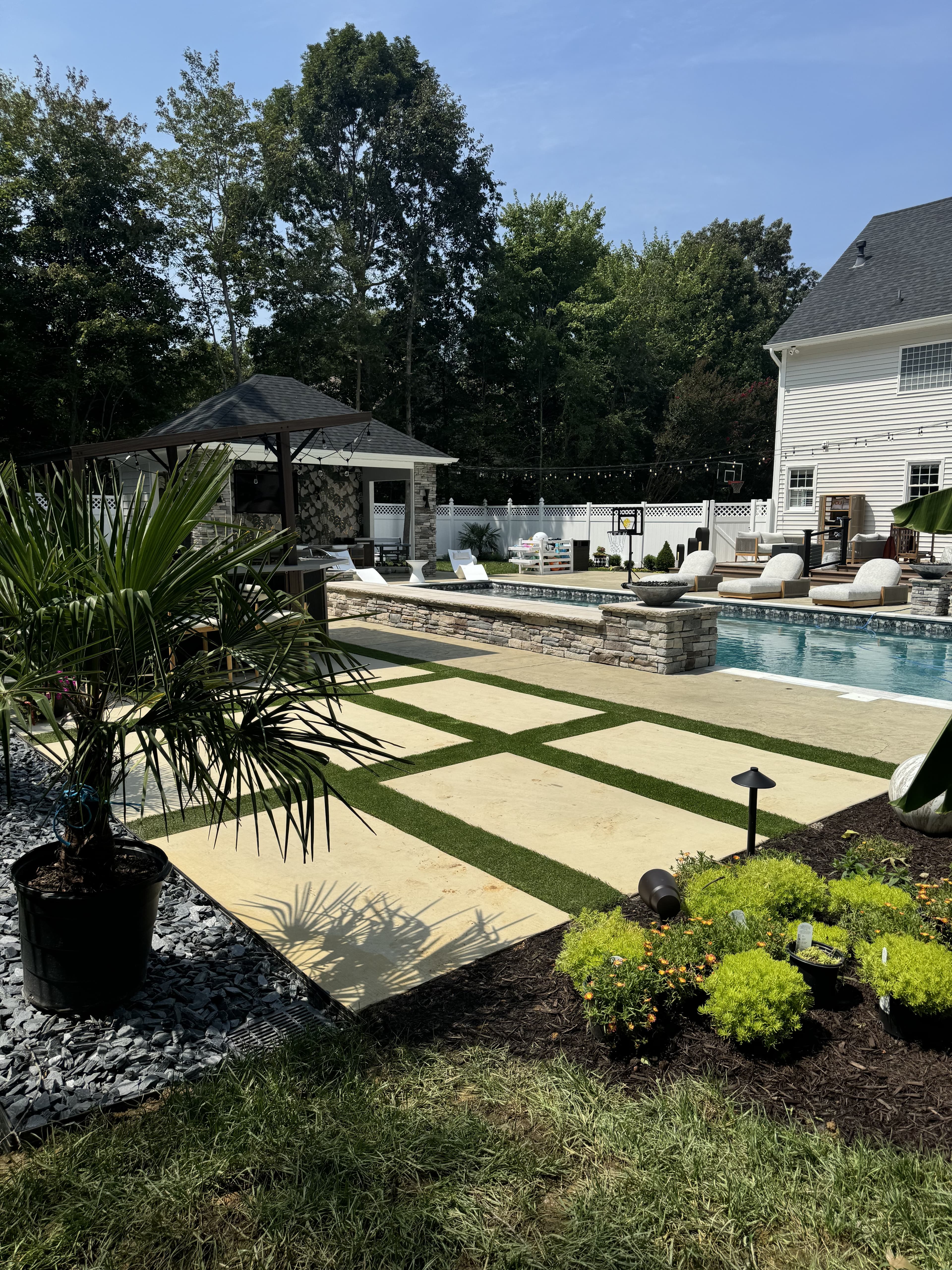 Multi-level pool area with stone retaining wall, premium decking, and landscaping.